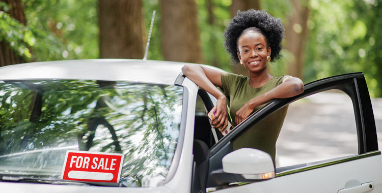 Woman standing beside a car